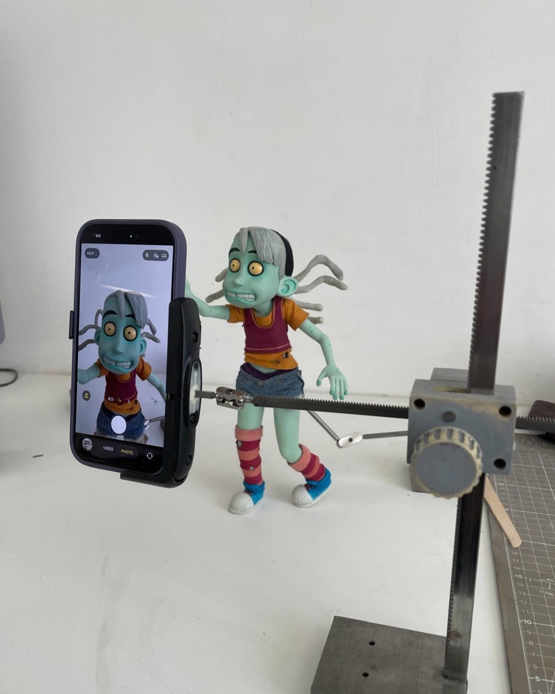 Zoé held by an articulated rig, filmed on a phone during animation